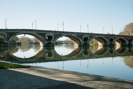 Pont Neuf in Toulouse, France, and its reflection on the Garonne river