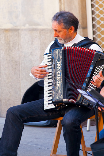 Folk musician wearing traditional clothing , playing accordion in pedestrian street during San Froilán annual celebrations, Lugo city, Galicia, Spain.