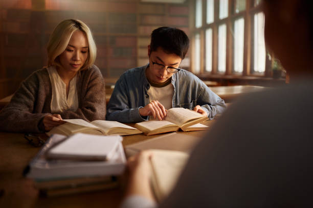 istock Asian college friends studying for exams in library. 2140258649