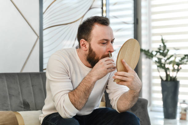 istock Male Clipping Excess Hair In Nose While Looking In Mirror 2140277404
