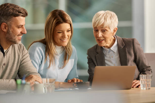 istock Happy couple using laptop with their financial advisor in the office. 2140277636