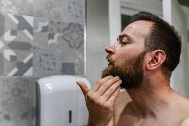 Side View Of Bearded Male Using Grooming Oils For His Beard