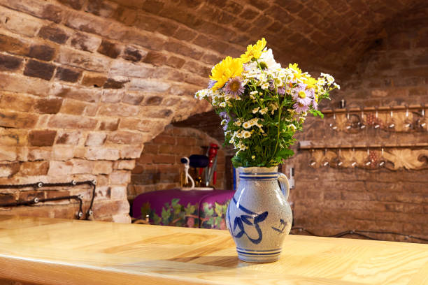 Vase with chrysanthemums and daisies on a bar counter in a stone basement