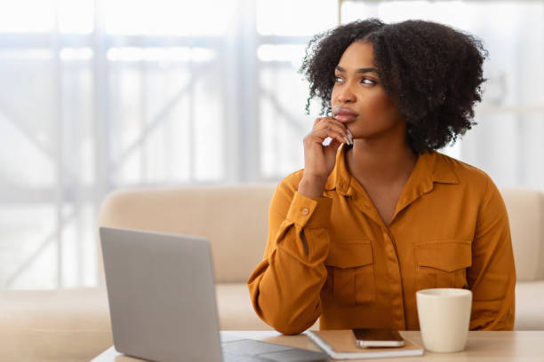 istock Concentrated pensive millennial curly black lady student manager with computer think 2140346083
