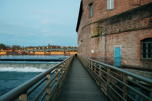 A wooden walkway by the Garonne river in Toulouse, at night