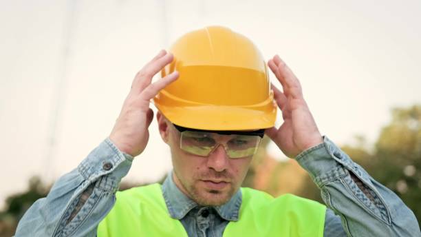 istock Weary builder removing his protective helmet after work on site 2140374754
