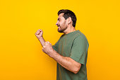 Photo portrait of nice young male raise fists fighting irritated reaction dressed stylish khaki garment isolated on yellow color background