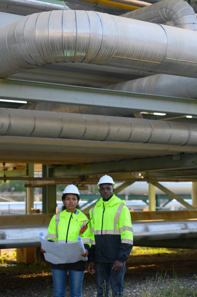istock Male and female engineers check the drawing system inspection with the real pipe system of the new construction project, engine engineer, Sysetm cooling machine, compared to drawing design. 2140382144