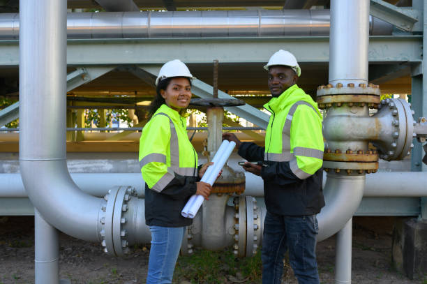 istock Male and female engineers check the drawing system inspection with the real pipe system of the new construction project, engine engineer, Sysetm cooling machine, compared to drawing design. 2140382145