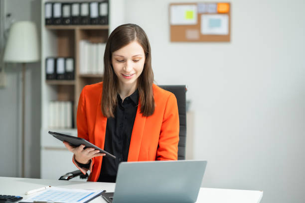 istock Businesswoman hand working with tablet and laptop computer with documents on office desk in modern office. 2140412823