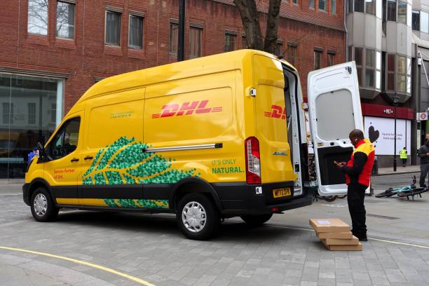 dhl ford e-transit parcel delivery van - driving delivery van global business dhl imagens e fotografias de stock