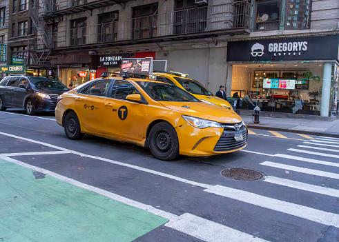 Manhattan, New York, USA - March, 2024.  Yellow cab at a cross walk in Manhattan near 42nd St.