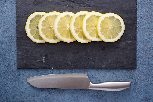 Close up of lemon slices on a slate plate on a kitchen countertop.