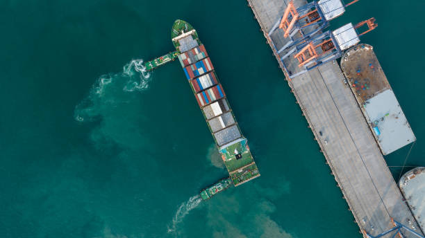 istock Tug boat pulling Cargo Container Ship into Cargo international sea port. Freight forwarding service logistics and transportation. International Shipping Custom Port for import export 2140475536