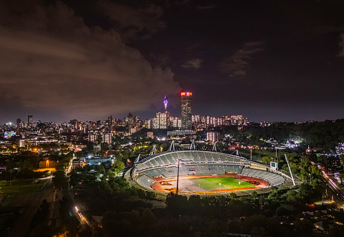 Johannesburg, South Africa - March 28, 2024: Johannesburg panoramic at a distance showing Hillbrow and Ellis Park athletics stadium lit up at night. Johannesburg is one of the forty largest metropolitan cities in the world, and the world's largest city that is not situated on a river, lakeside, or coastline.