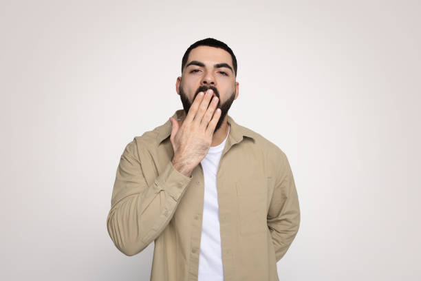 istock Surprised young man with a beard covering his mouth with hand 2140480319