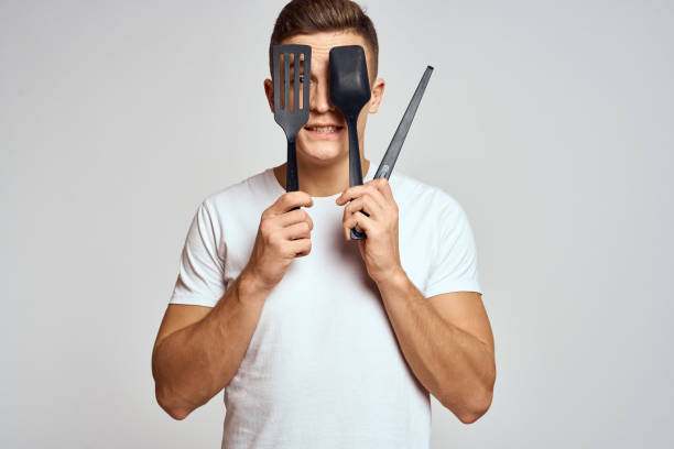 istock Guy with kitchen tools in hands on a light background cropped view of emotions fun model 2140485196