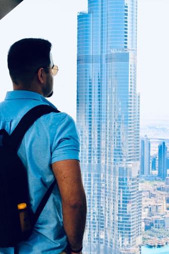 Captured in this stunning image is a moment of wonder as the viewer stands in awe, gazing upon the majestic silhouette of the Burj Khalifa in Dubai. Against the backdrop of a vibrant skyline, the world's tallest building rises into the sky, exuding an aura of grandeur and elegance. With its sleek architecture and towering height, the Burj Khalifa symbolizes the city's spirit of innovation and ambition. As the sun sets behind the iconic landmark, casting a warm glow over the scene, one can't help but marvel at the beauty and magnificence of Dubai's skyline. This photograph invites viewers to experience the magic of Dubai, where modern marvels and timeless beauty converge in perfect harmony.