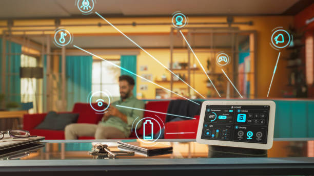 istock Creative Smart Home Device with Infographics Shown on Display and Icons Around Display. Person using Smartphone to Control His stylish House. IOT High-Tech Connected Wireless Intelligent System 2140493144