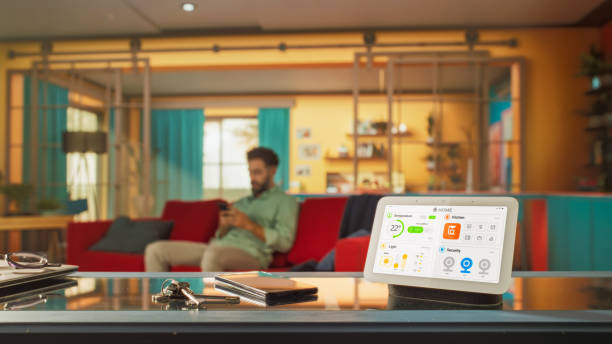 istock Creative Smart Home Device with Light Theme Infographics Shown on Display and Icons Around Display. Person using Smartphone to Control His stylish House. IOT Connected Wireless Intelligent System 2140494215