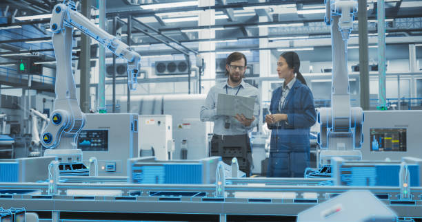 istock Electronics Factory Digitalization: Automated Robot Arm Assembly Line Manufacturing Equipment. Managers Discussing Work while Futuristic AI Computer Vision Analyzing, Scanning Production Line 2140496403