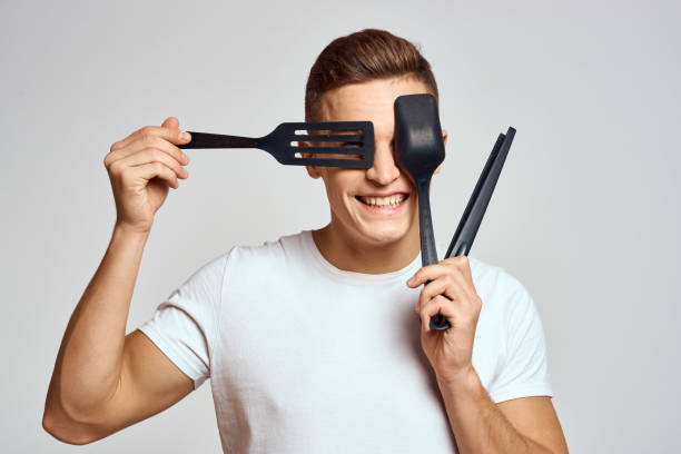 istock Guy with kitchen tools in hands on a light background cropped view of emotions fun model 2140496432