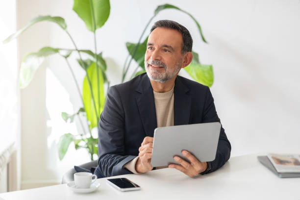 istock Optimistic mature businessman with a tablet in hand and a joyful expression 2140503411