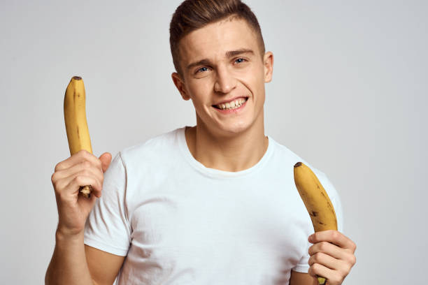 istock guy with a banana in his hand on a light background fun emotions light background white t-shirt model 2140510861