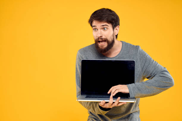 istock man with laptop wireless technology internet lifestyle work yellow isolated background 2140516726