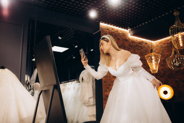 istock beautiful bride trying on a wedding dress 2140523060