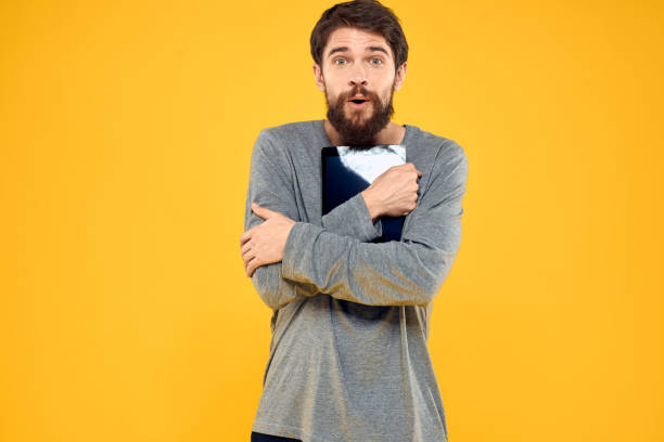 istock Emotional man with tablet in hands technology internet device lifestyle yellow background 2140528832