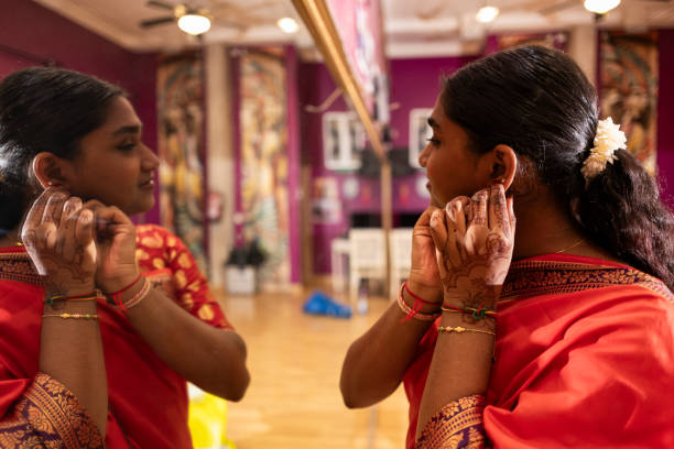 istock Young Indian Woman Adjusting Earrings in Mirror Reflection 2140540436