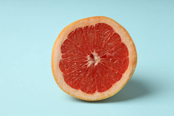 istock Half of grapefruit on blue background, close up 2140556267