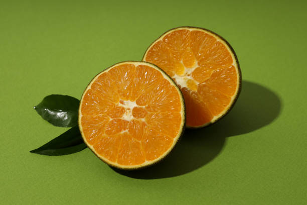 istock Chocolate orange with leaves on green background 2140557325