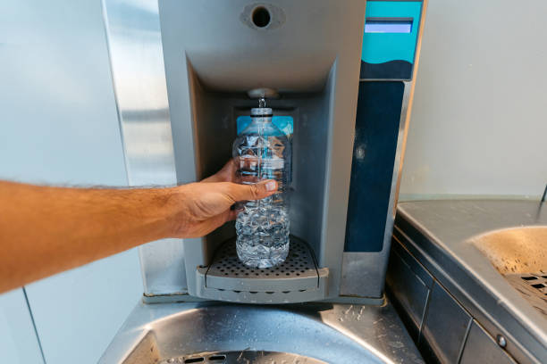 Cold water is flowing from water dispenser to glass in home. Healthy water concept in summer.
