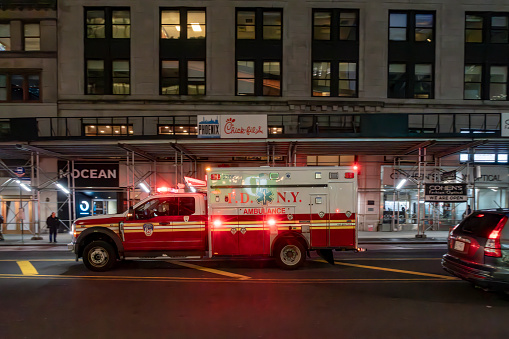 Manhattan, New York, USA - March, 2024.  New York fire department ambulance on a Manhattan Street at night.