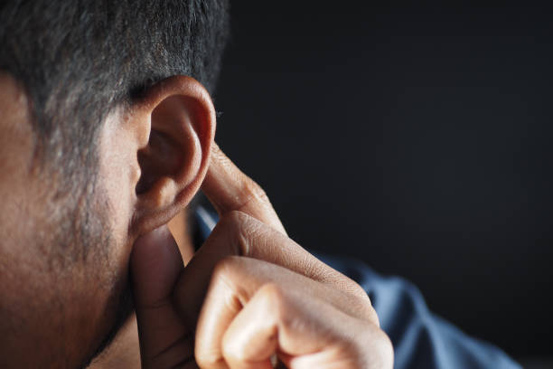 istock young man having ear pain touching his painful ear , 2140616953