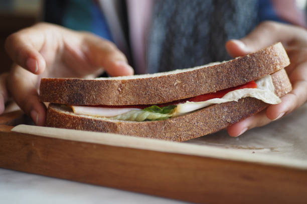 istock women hand pick Sandwich with ham, cheese, tomatoes,, 2140625431