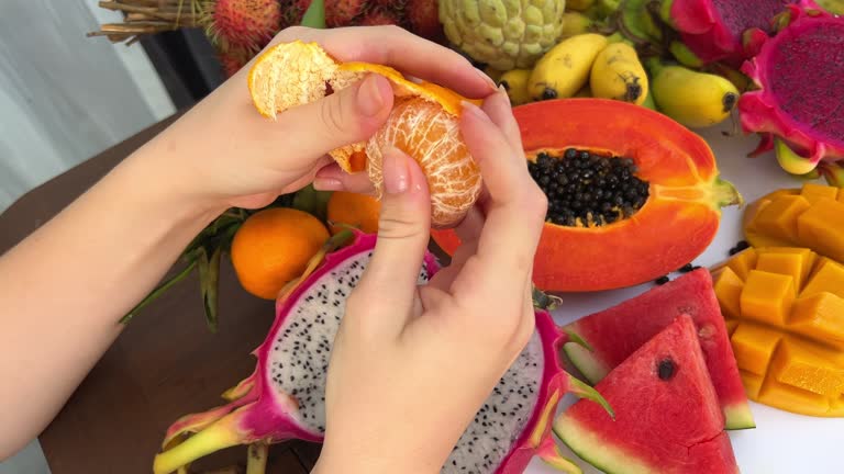 hands peel ripe tangerine.close-up Peel the tangerine peel