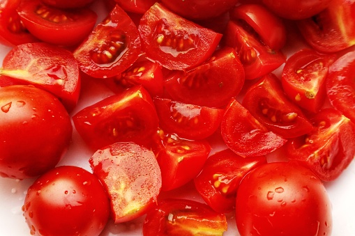 Close-up view of a tomato being cut into pieces. and fresh organic fruits using the Hydroponics method. Plants that nourish the skin help whiten and brighten the skin.
