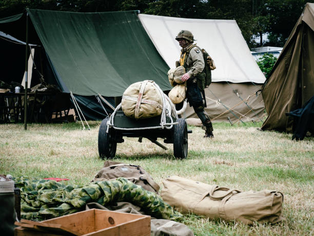Second world war commemoration. Military camp reconstitution Unidentified soldiers people next to tents, military american war vehicles.