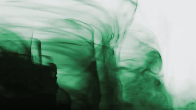 A swirl of black and green ink on a light background