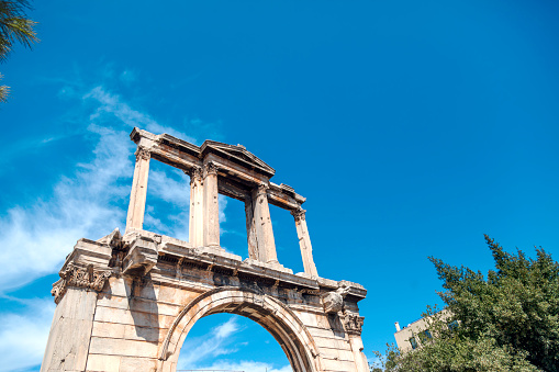 Behold the majestic Hadrian's Arch standing tall against the backdrop of a clear blue sky on a sunny summer day in Athens, Greece. This iconic structure, built in the 2nd century AD, serves as a lasting tribute to the Roman Emperor Hadrian's visit to the city. Admire the intricate details of this ancient marvel as it frames the bustling streets of Athens, inviting visitors to delve into its rich historical significance. Experience the timeless beauty and architectural mastery of Hadrian's Arch, a symbol of the enduring bond between Greece and the Roman Empire.