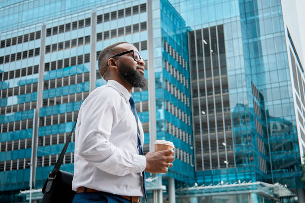 istock Professional Black Man Walking in City with Coffee and Briefcase 2140692446
