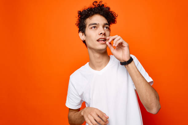 istock handsome man white t-shirt hand gestures emotions orange background 2140693519