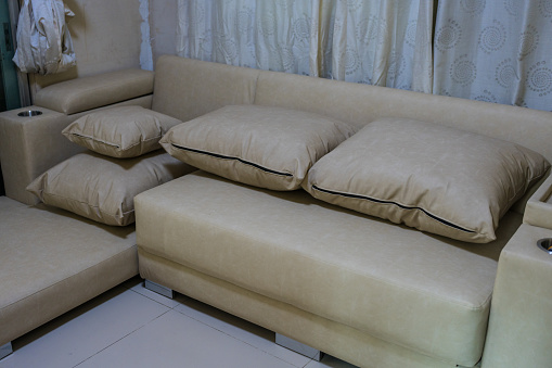 Gray and white pillows on beige sofa