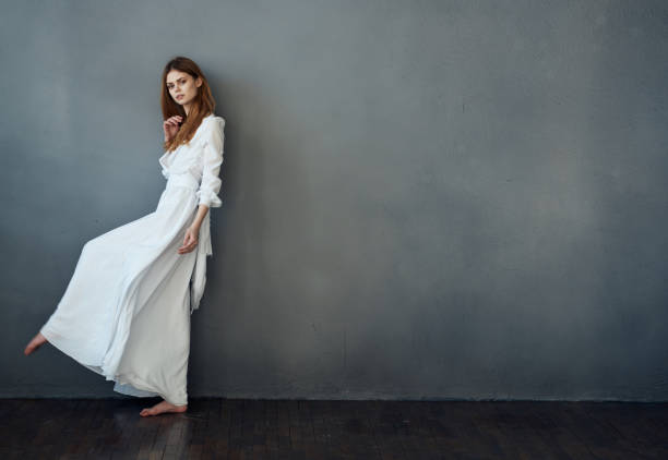 istock attractive woman white dress luxury performance studio gray background 2140740014