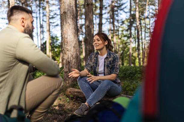 istock Happy Couple Engaged in Talk by Tent in Forest 2140756964