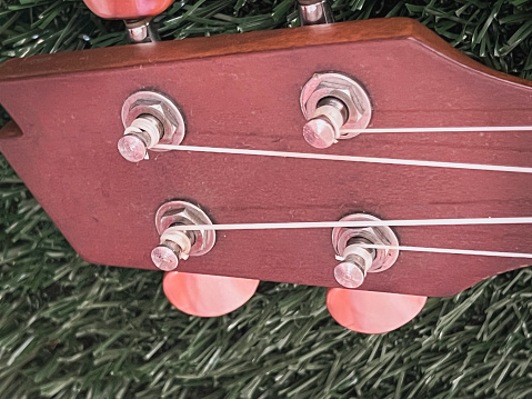 Ukulele headstock with tuning pegs made from wood,use for set up sound,parts of acoustic instrument.,Lens flare effect