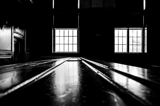 Judge's bench with sunlight pouring through windows into unlit room